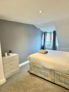 a bedroom with a large bed and a dresser at Large City Centre Room in Bristol