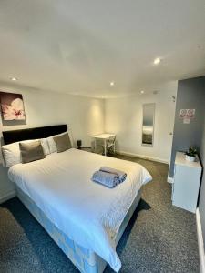 a bedroom with a large white bed and a desk at Large City Centre Room in Bristol