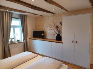1 Schlafzimmer mit 2 Betten, einem Schrank und einem TV in der Unterkunft Ferienwohnungen Schneider in Lennestadt