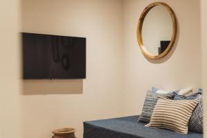 ein Wohnzimmer mit Fernseher und Couch mit Spiegel in der Unterkunft Buckingham Mews Pebble Cottage 3 in Broadstairs