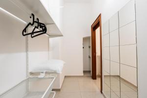 einen Flur mit weißen Wänden und einem Eingang aus Glas in der Unterkunft Il Viccio Apartment in Palo del Colle