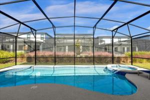 een groot zwembad in een gebouw met een glazen omheining bij Top Villas - Paradiso Grande 5 in Orlando