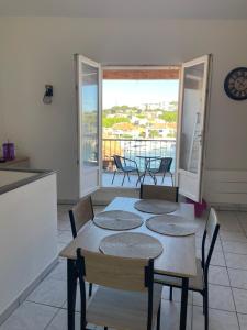 a kitchen and dining room with a table and chairs at Appartement des Ponts Bleus in Martigues