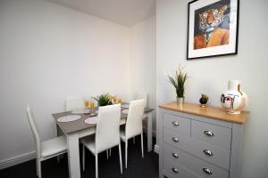 a dining room with a table and white chairs at Bellevue by Tŷ SA - Modern 3 bed in Newport in Newport