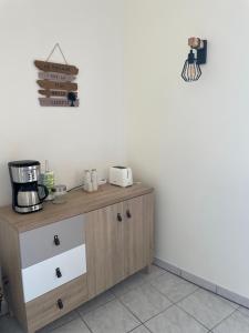 a kitchen with a wooden cabinet with a coffee maker on it at Appartement des Ponts Bleus in Martigues