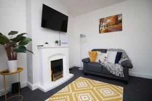 a living room with a couch and a fireplace at Bellevue by Tŷ SA - Modern 3 bed in Newport in Newport