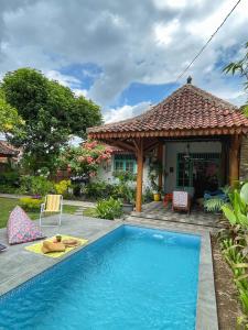 a house with a swimming pool and a gazebo at Summergrass B&B in Yogyakarta
