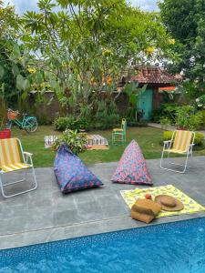 una mesa con chanclas y almohadas junto a la piscina en Summergrass B&B, en Yogyakarta