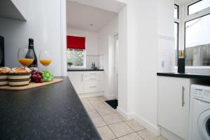 a kitchen with a counter with two glasses of wine at Bellevue by Tŷ SA - Modern 3 bed in Newport in Newport
