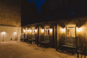 eine Reihe von Fenstern auf einem Backsteingebäude in der Nacht in der Unterkunft Buckingham Mews Pebble Cottage 3 in Broadstairs