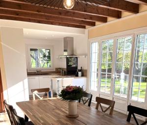 a kitchen and dining room with a wooden table and chairs at Belle Maison Bretonne Trébeurden - Ty Kerel in Trébeurden