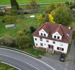 a large white house with a brown roof next to a road at Schöne Wohnung mit Erker 