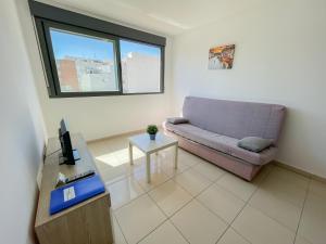 uma sala de estar com um sofá e uma mesa em Apartamentos Benicarló Lowcost 3000 em Benicarló