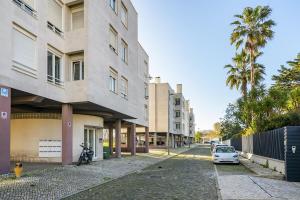 une voiture blanche garée dans une rue à côté d'un bâtiment dans l'établissement WHome Cosy Urban Hideaway in Belém with River View, à Lisbonne