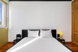 Un dormitorio con una gran cama blanca con dos almohadas. en Lisbon Riverview Apartment by Premium Lisbon Stays, en Lisboa