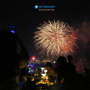 a firework display at night with a city in the background at Wyndham Danang Golden Bay in Da Nang