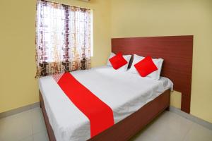 - une chambre avec un grand lit et des oreillers rouges dans l'établissement OYO Flagship Hotel Sai Saugat, à Bilāspur