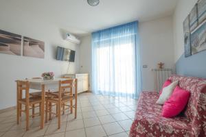 ein Wohnzimmer mit einem Tisch und einem Sofa in der Unterkunft Green Bay C12 - Pineto Vacanza in Pineto