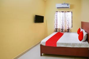 - une chambre avec un lit doté d'oreillers rouges et une fenêtre dans l'établissement OYO Flagship Hotel Sai Saugat, à Bilāspur