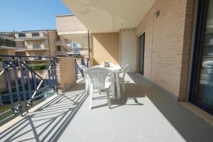 eine Terrasse mit einem Tisch und Stühlen auf dem Balkon in der Unterkunft Green Bay C12 - Pineto Vacanza in Pineto