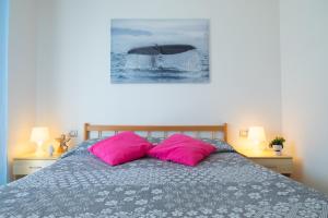 ein Schlafzimmer mit einem Bett mit zwei rosa Kissen in der Unterkunft Green Bay C12 - Pineto Vacanza in Pineto