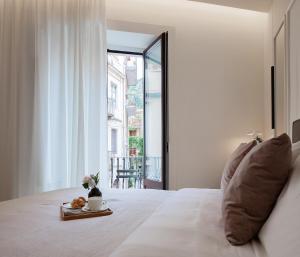 1 dormitorio con 1 cama y vistas a un balcón en Maia Flora Taormina Apartments en Taormina