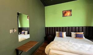 1 dormitorio con 2 camas y espejo en FabHotel Niraant, en Surat