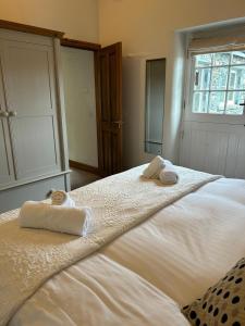a bedroom with a large white bed with towels on it at Deer Close Cottage in Keswick