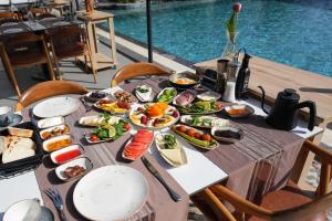 Ramitos Boutique Hotel في مرماريس: طاولة مع أطباق من الطعام بجوار حمام سباحة