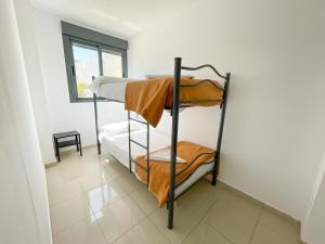um quarto com 2 beliches e uma janela em Apartamentos Benicarló Lowcost 3000 em Benicarló