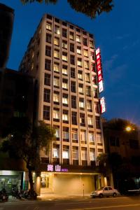a tall building with a sign in front of it at Songshan Hotel in Kaohsiung