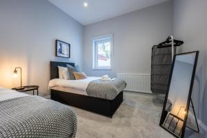 a bedroom with two beds and a mirror at Brynglas House by Tŷ SA in Newport