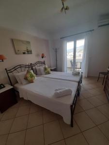 1 dormitorio con 1 cama grande con sábanas blancas en Romantica Hotel, en Agia Pelagia - Citera