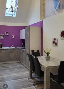 a dining room with a table and a purple wall at Ferienwohnung Jasmin in Rust