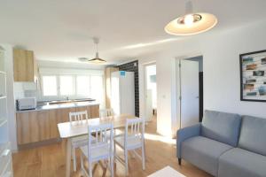 een woonkamer met een tafel en stoelen en een bank bij Notel Club - Vistalmar apartamento en Cueto in Santander