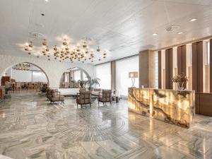 a lobby of a hotel with chairs and a fireplace at Civitel Akali Hotel in Chania