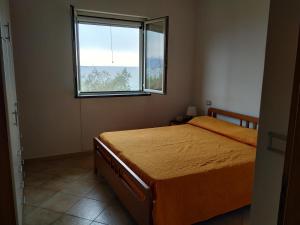 1 dormitorio con cama y ventana en Elvira Residence Villammare, en Villammare