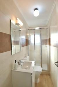 W łazience znajduje się umywalka, toaleta i lustro. w obiekcie Notel Club - Vistalmar apartamento en Cueto w mieście Santander