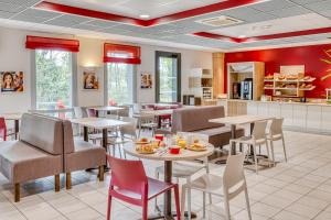 un restaurant avec des tables et des chaises et une cuisine dans l'établissement Ace Hotel Bordeaux Cestas, à Cestas
