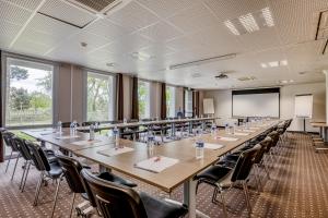 ein großer Konferenzraum mit einem langen Tisch und Stühlen in der Unterkunft Ace Hotel Bordeaux Cestas in Cestas