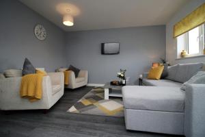 a living room with two couches and a tv at Buxton Way by Tŷ SA - 3 bedroom house in Royal Wootton Bassett