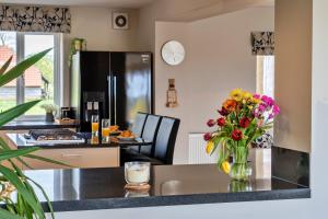 eine Küche mit einem Tisch und einer Vase aus Blumen in der Unterkunft Finest Retreats - Stone Bow Farmhouse in Weston-super-Mare