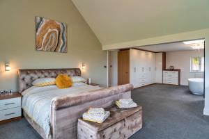 ein Schlafzimmer mit einem großen Bett und einer Badewanne in der Unterkunft Finest Retreats - Stone Bow Farmhouse in Weston-super-Mare