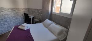 a bedroom with a white bed and a window at Habitaciones El Escorial in Majadahonda