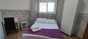 a small bedroom with a bed and a window at Habitaciones El Escorial in Majadahonda