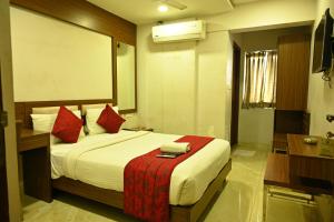 sypialnia z dużym łóżkiem z czerwonymi poduszkami w obiekcie HOTEL ROYAL PARK w mieście Nellur
