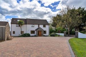 a large white house with a brick driveway at Finest Retreats - Stone Bow Farmhouse in Weston-super-Mare