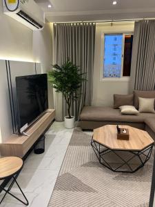 un soggiorno con divano e TV a schermo piatto di Elite House a Taif