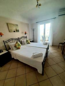 Un dormitorio con una cama grande y una ventana en Romantica Hotel, en Agia Pelagia - Citera