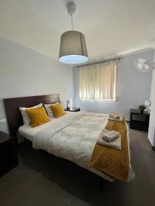 a bedroom with a large bed with yellow pillows at UIM Mediterraneo Churruca Wifi in Puerto de Sagunto